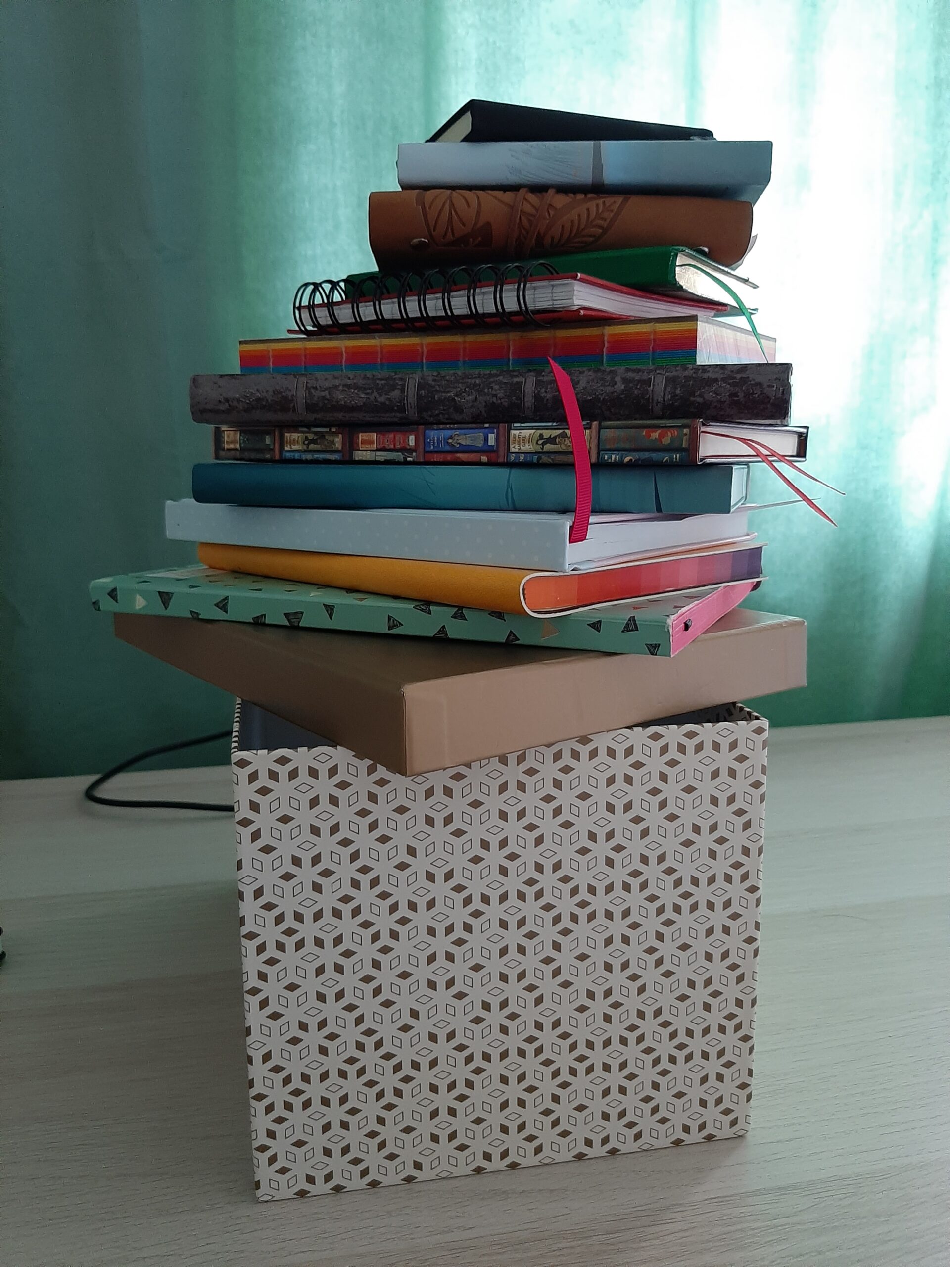 pile of writer's notebooks balanced on box